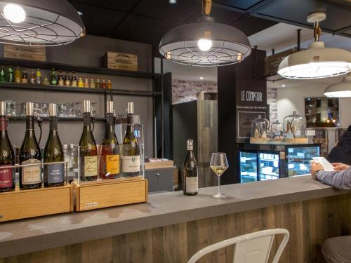a bar with a bunch of bottles of wine at ibis Lyon Sud Vienne Saint-Louis in Vienne