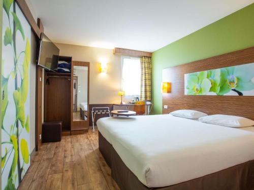 a hotel room with a large bed and a desk at Hôtel Ibis Styles Bourges - Piscine extérieure chauffée - Restaurants à proximité in Bourges
