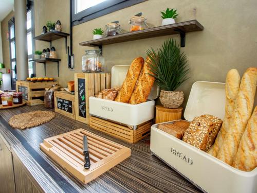 a bakery counter with breads and baskets of bread at Hôtel Ibis Styles Bourges - Piscine extérieure chauffée - Restaurants à proximité in Bourges