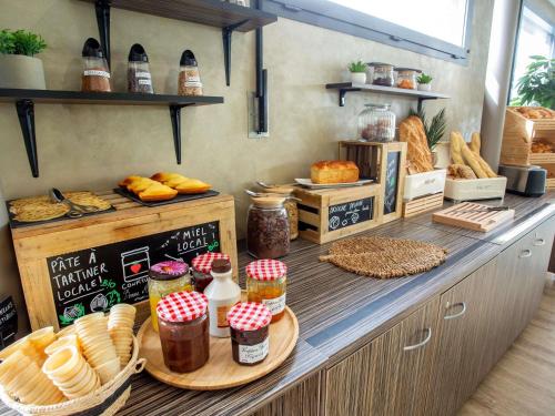 a bakery counter with bread and other food items at Hôtel Ibis Styles Bourges - Piscine extérieure chauffée - Restaurants à proximité in Bourges