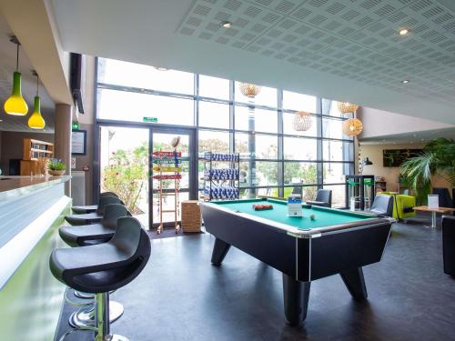 a billiard room with a pool table and chairs at Hôtel Ibis Styles Bourges - Piscine extérieure chauffée - Restaurants à proximité in Bourges