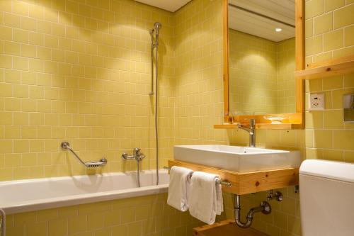 a bathroom with a sink and a tub and a toilet at Chalet Annelis Apartments in Zermatt