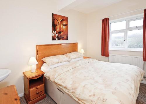 a bedroom with a large bed and a window at Anglesey Bungalows in Trearddur