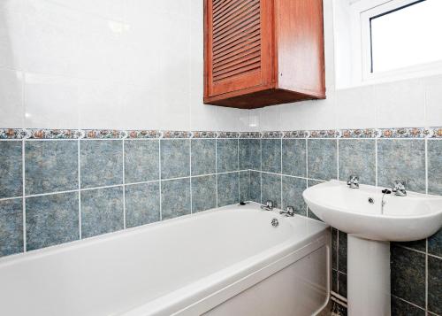 a bathroom with a bath tub and a sink at Anglesey Bungalows in Trearddur