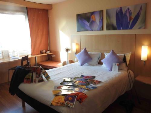 a hotel room with a bed with books on it at ibis Hotel Muenchen City West in Munich