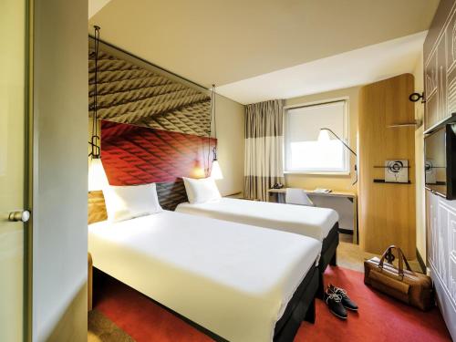 a hotel room with two beds and a window at ibis Hotel Muenchen City West in Munich