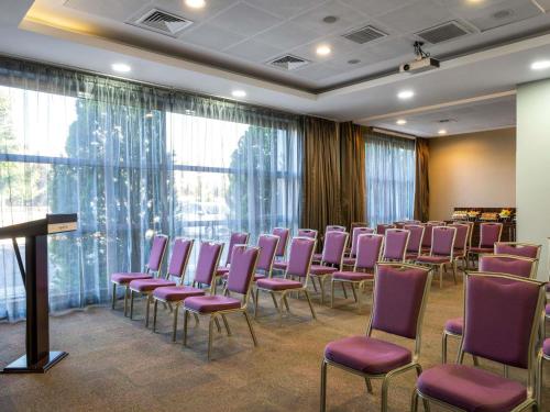 a conference room with purple chairs and a podium at Novotel Kayseri in Kayseri