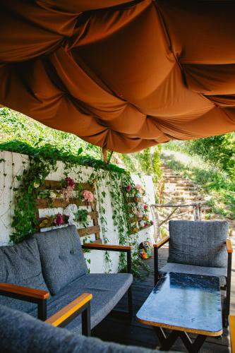 a patio with two chairs and an umbrella at Glamping Drina Riverzone in Goražde