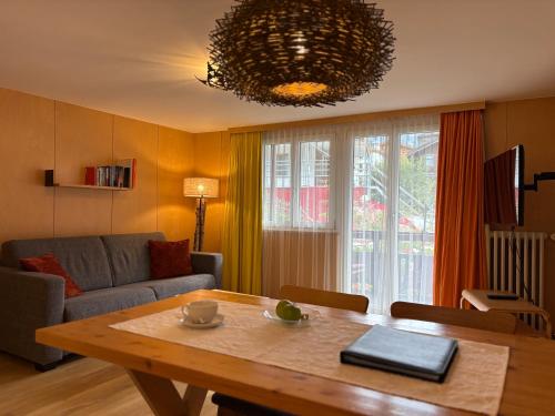 a living room with a table and a couch at Chalet Annelis Apartments in Zermatt