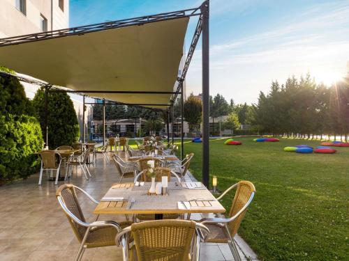 a patio with tables and chairs and a field of grass at Ibis Kayseri in Kayseri