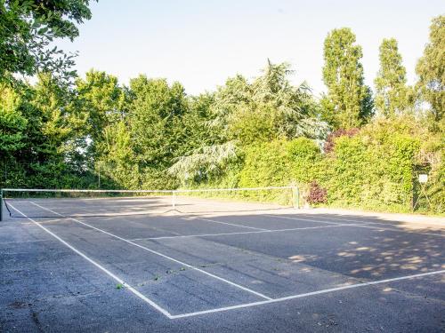 a tennis court with a net in the middle at The Stables in Clyst Saint Mary