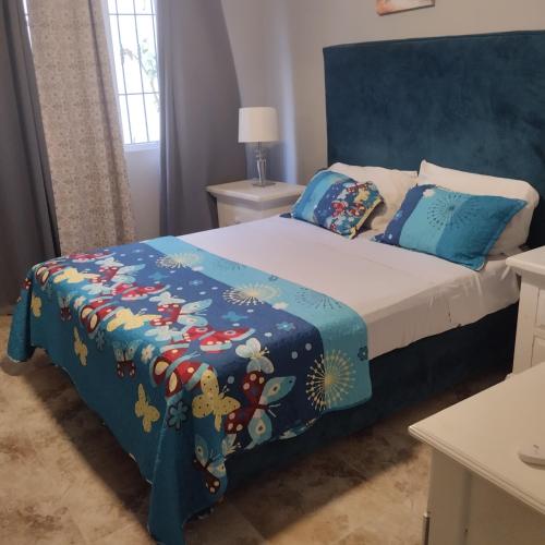 a bedroom with a bed with a blue headboard at Nely y Pietro share apartment in Punta Cana