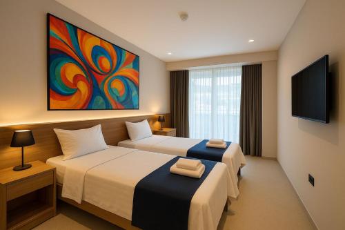 a hotel room with two beds and a tv at Hotel & Restaurant HAREA in Suharekë