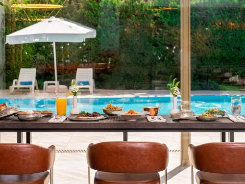 a table with food on it in front of a pool at Novotel Gaziantep in Gaziantep