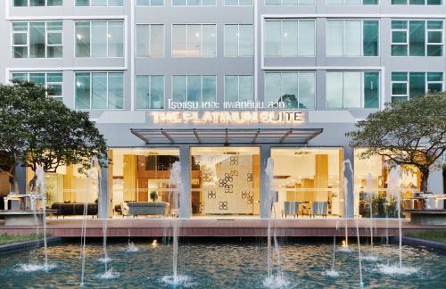 a building with a fountain in front of it at Sunday Platinum Suites in Bangkok