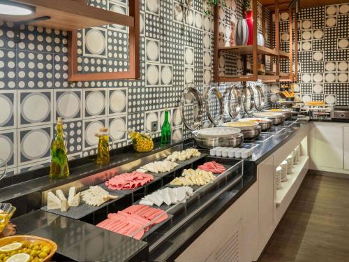 a buffet line with plates and food on display at Novotel Gaziantep in Gaziantep