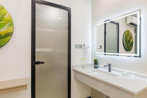 a bathroom with a sink and a mirror at 厦门初默民宿 in Xiamen