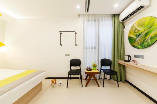 a bedroom with two chairs and a bed and a desk at 厦门初默民宿 in Xiamen