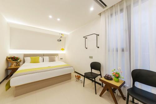 a bedroom with a bed and a desk and a chair at 厦门初默民宿 in Xiamen