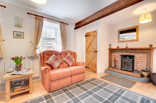 a living room with a chair and a fireplace at The Shippon in Askrigg in Askrigg