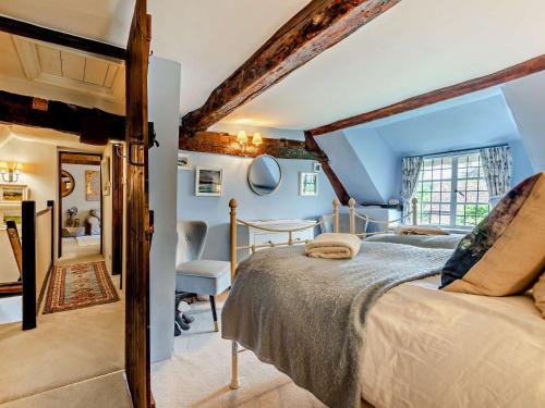 a bedroom with a bed and a chair in a room at 3 bed property in Blandford Forum 83442 in Tarrant Monkton