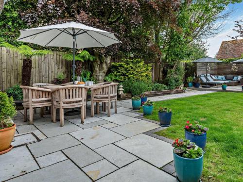 a patio with a table and an umbrella in a yard at 3 bed property in Blandford Forum 83442 in Tarrant Monkton