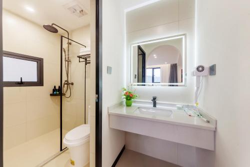 a bathroom with a sink and a toilet and a mirror at 厦门初默民宿 in Xiamen