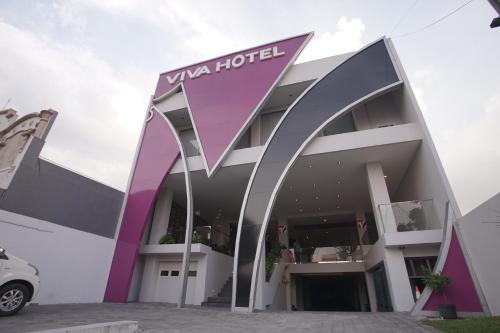a building with a sign for a viva hotel at Viva Hotel Kediri, Azana Hotels Collection in Kediri