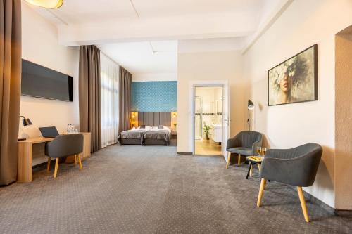 a hotel room with a bed and a desk and chairs at Hotel Polonia Centrum in Wrocław