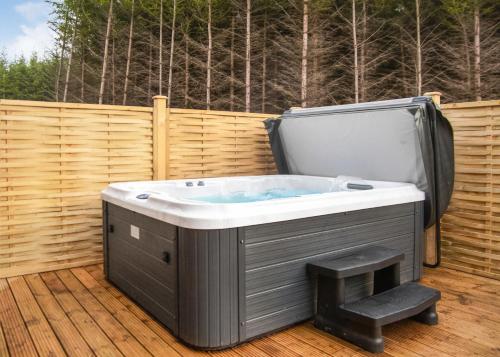 a jacuzzi tub sitting on a deck at Thirlestane Woodland Lodges in Lauder