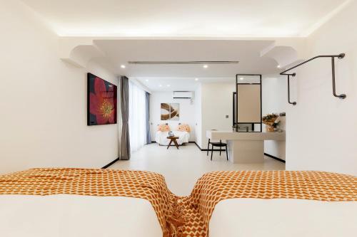 a white room with two beds and a desk at 厦门初默民宿 in Xiamen