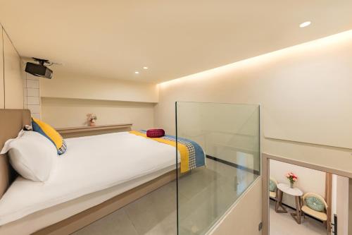 a small bedroom with a bed and a glass wall at 厦门初默民宿 in Xiamen
