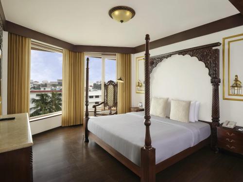 a bedroom with a canopy bed and a large window at Novotel Mumbai Juhu Beach in Mumbai
