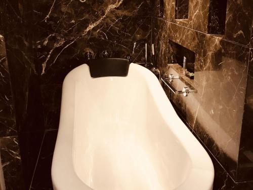 a white urinal in a bathroom with a black wall at Novotel Mumbai Juhu Beach in Mumbai
