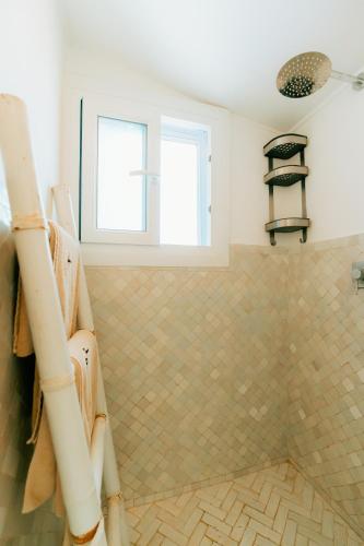 a bathroom with a tiled shower with two windows at Dakhla Attitude in Dakhla