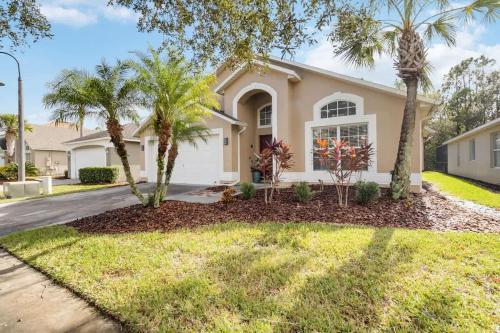 a house with palm trees in front of a driveway at Vacation Home near Disney World! in Kissimmee