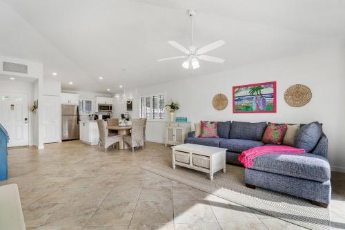 a living room with a blue couch and a kitchen at PGA National Getaway Cozy Club Cottage in Palm Beach Gardens