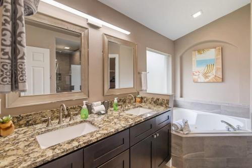 a bathroom with two sinks and a tub and a large mirror at Vacation Home near Disney World! in Kissimmee