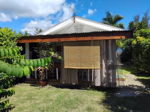 a guest house with a thatched roof at La maison du Lac in Temae