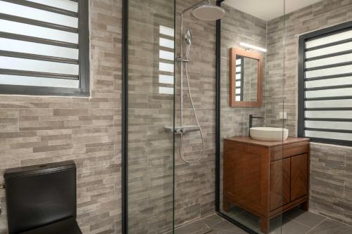 a bathroom with a shower with a toilet and a sink at Villa Amazonie near new hospital private pool in Les Abymes