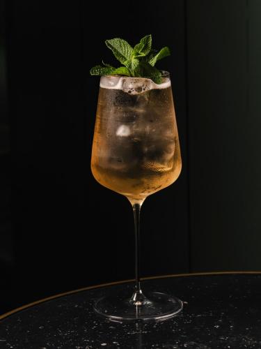 a drink in a glass with a mint leaf on top at The Social Hub Barcelona Poblenou Extended Stay in Barcelona