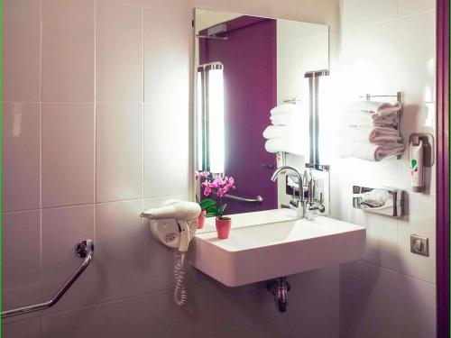 a bathroom with a white sink and a mirror at ibis Styles Angers Centre Gare in Angers