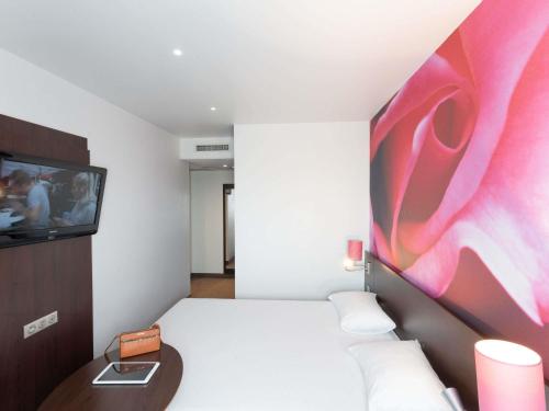a hotel room with a bed and a tv at ibis Styles Angers Centre Gare in Angers