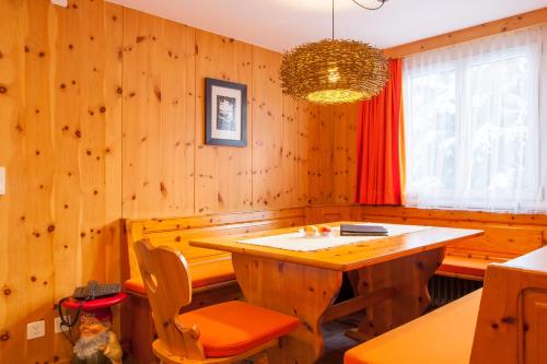 a dining room with wooden walls and a table and chairs at Chalet Annelis Apartments in Zermatt