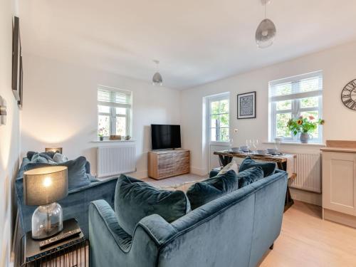 a living room with a blue couch and a tv at Forest Acorn in Brockenhurst