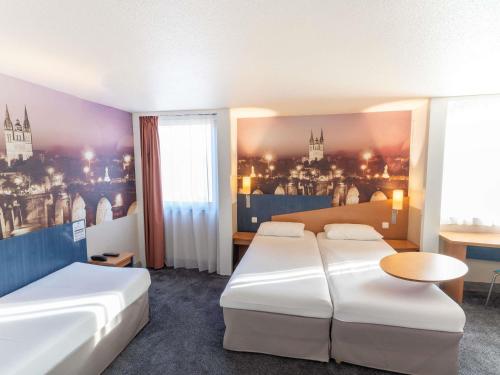 a hotel room with two beds and a table at ibis Styles Angers Centre Gare in Angers