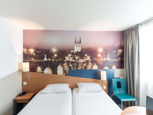 a room with two beds and a painting on the wall at ibis Styles Angers Centre Gare in Angers