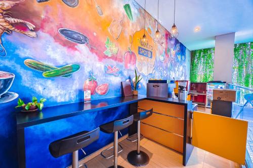 a kitchen with a colorful mural on the wall at Viva Hotel Kediri, Azana Hotels Collection in Kediri