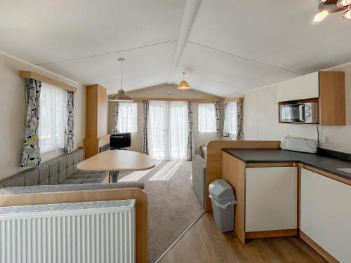 a kitchen and living room with a couch and a table at Peppy in Newton Stewart