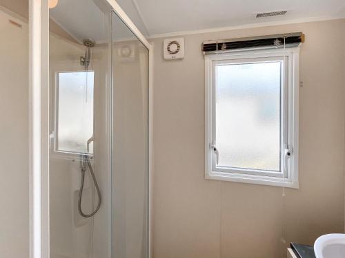 a bathroom with a shower and a window at Peppy in Newton Stewart